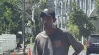 Tangkapan layar video yang memperlihatkan seorang pria diduga juru parkir liar menghadang kendaraan di kawasan Kambang Iwak dekat SD Kartika Palembang. Foto: Sosmed